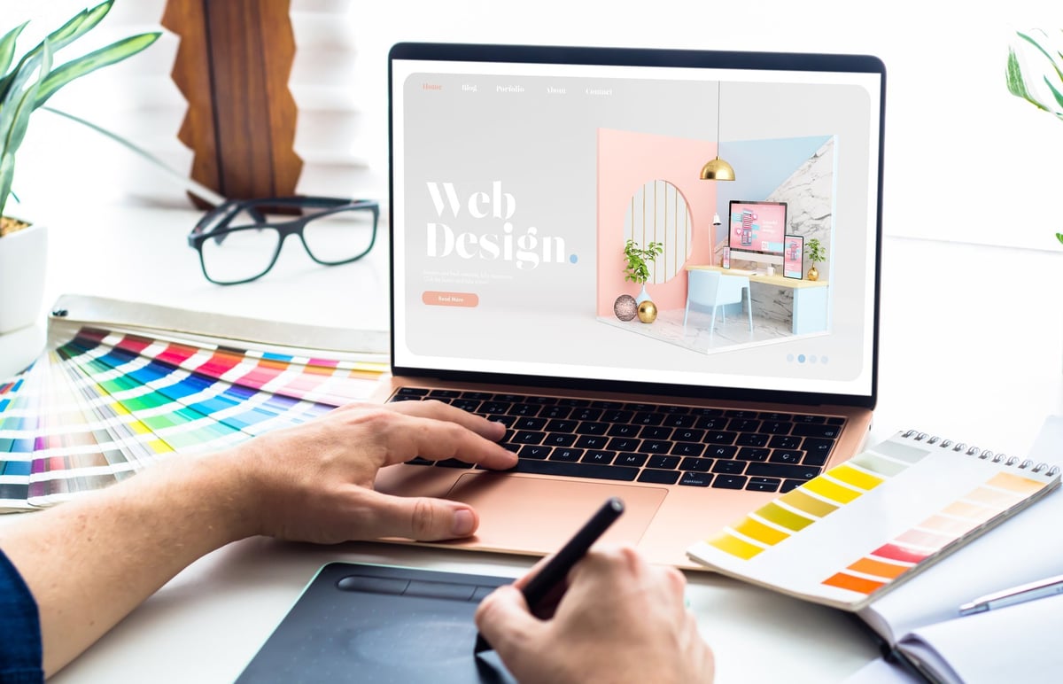 Web design workspace with laptop showing website development